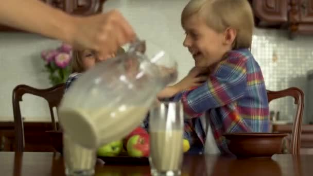 Hand Mother Pouring Milk Glasses Kids Foreground Two Children Fighting — Stock Video