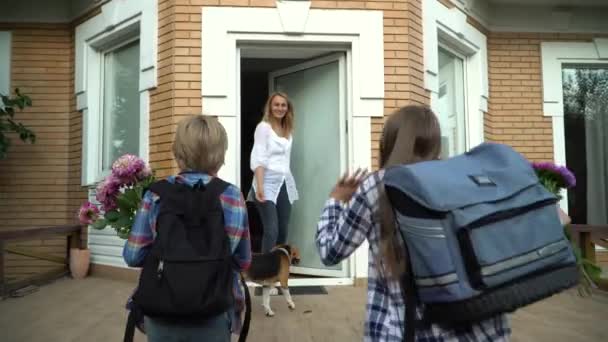 Kleine Schattige Jongen Meisje Met Rugzakken Die Thuiskomen Bloemen Brengen — Stockvideo