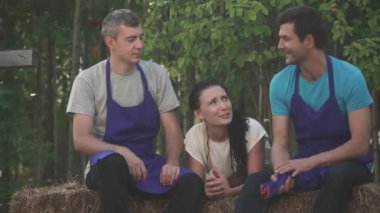 Mavi üniformalı işçiler ve kadınlar dinleniyor. İnsanlar birlikte konuşur ve gülerler. Dışarıda vakit geçirmek.