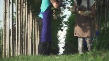 İnsanlar bahçeden kesilmiş dallar topluyor. Kadın, bahçıvanlar tarafından kesilen dalları alıp başka bir işçiye veriyor. İnsanlar işlerini dikkatli yaparlar..