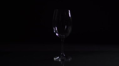 Kırmızı şarap kadehine dökülür, koyu arka plan, stüdyo videosu.