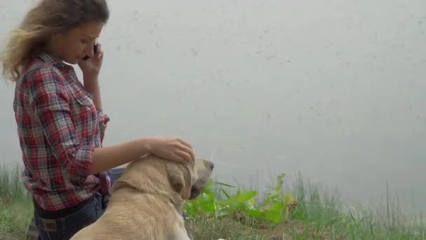 Hablando Por Teléfono Móvil Mujer Pelo Rizado Perro Labrador Lago — Vídeos de Stock