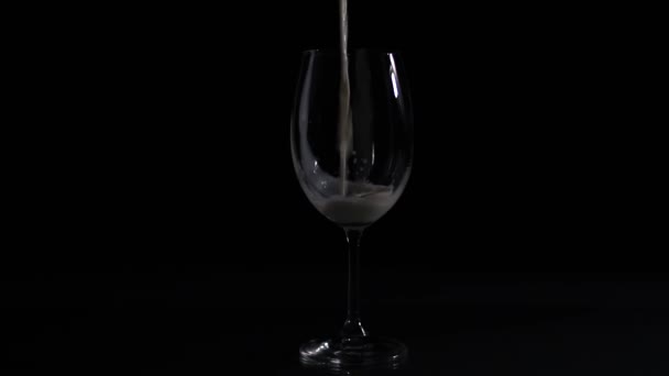 黑色背景下的空杯子 牛奶倒入一个空杯子里 牛奶倒入杯子 滴在桌上 黑色背景 — 图库视频影像