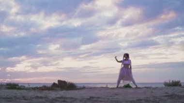 Açık havada dans eden pembe elbiseli, parlak makyajlı güzel kız..