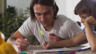 Masada birlikte otururken kağıt üzerine resim çizmek. Baba-çocuk ilişkisi.
