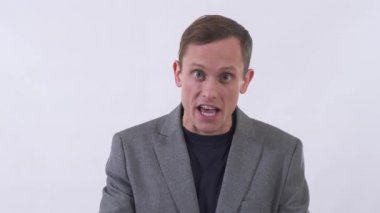 Takım elbiseli kızgın adamın portresi elinde belgelerle bağırıyor. İş adamı öfkeyle kağıtları fırlatır. Beyefendi faturalarını aldı ve muhasebe ile şok oldu. Beyaz bir arka planda stüdyoda çekim yapmak.