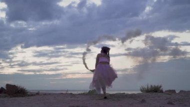 Açık havada dans eden pembe elbiseli, parlak makyajlı güzel kız..