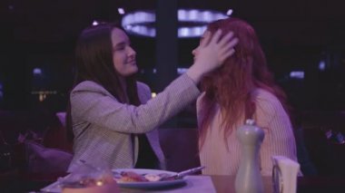 Sevimli genç kız, güzel kız arkadaşının alnından öpüyor..