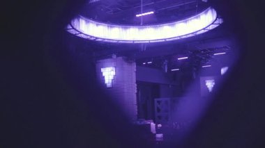 Mavi ışıktaki boş gece kulübünde ziyaretçi bekleyen bir sürü rahat koltuk ve masa var. Ahşap perdenin arkasından çekim