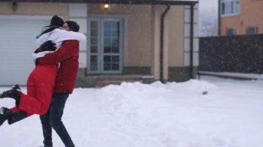 Kışın giysili sakallı bir adam kız arkadaşının etrafında dönüyor, hem gülüyor, hem yavaş çekim videosu. 