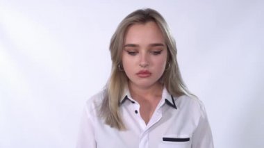 Yukarı aşağı bakan üzgün sarışın kadının videosu. Burnu delinmiş genç bir kadın poz veriyor. 