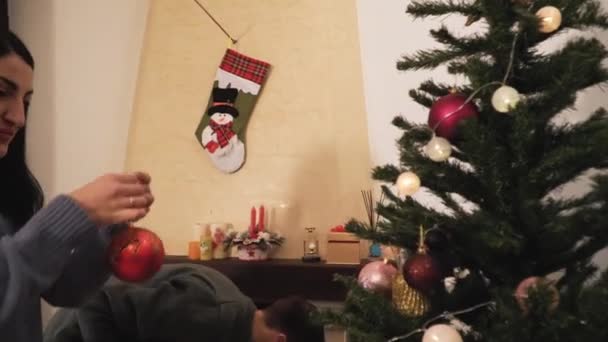 Молода Позитивна Пара Прикрашає Різдвяну Ялинку Кімнаті Новий Рік Різдво — стокове відео