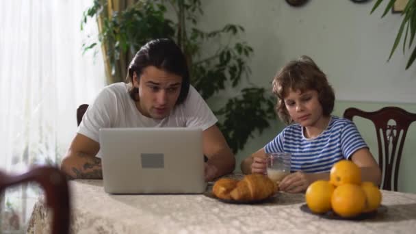 Kleine Leuke Jongen Eten Keukentafel Drinken Cappuccino Dan Geven Oranje — Stockvideo