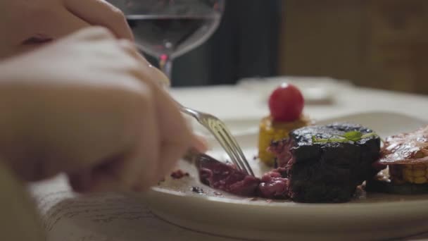 여자는 포크와 사용하여 맛있는 고기를 자르고 있었다 식당에서의 — 비디오