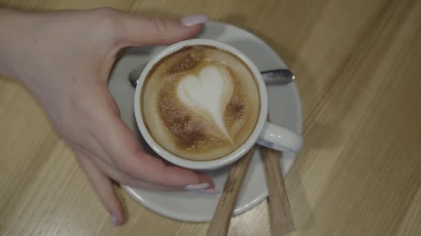 老人家的手拿着白咖啡 闭着嘴放回盘子里 女士在咖啡店里喝咖啡 盘子里有勺子和两根糖 顶部视图 — 图库视频影像