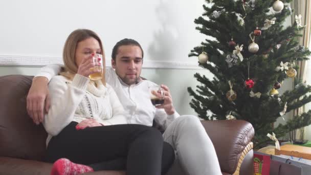 Joven Abrazando Novia Sentada Sofá Tomando Café Junto Árbol Navidad — Vídeo de stock