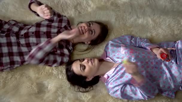 Две Симпатичные Сестры Близнецы Пижаме Лежат Мягком Ковре Лицом Друг — стоковое видео