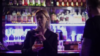 Gözlüklü, alkolik bir adam barın önünde elinde kokteyl olan bir kıza yaklaşır. Adam kıza uygunsuz bir teklifte bulundu ve kız çekip gitti..