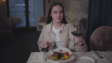 Güzel dolgun dudaklı, temiz tenli, restoranda kırmızı şarap içen güzel bir genç kız. Ağız manzarasını kapat