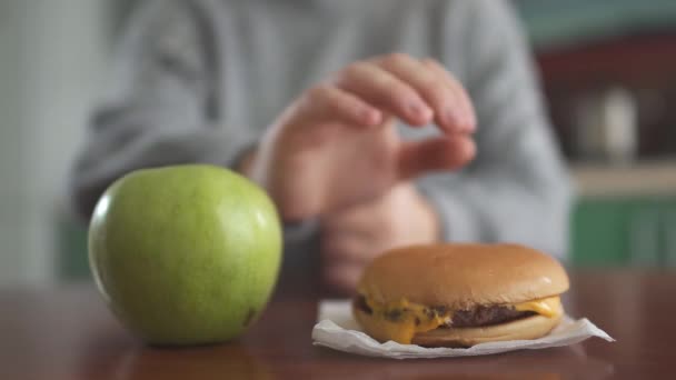 Nahaufnahme Von Apfel Und Burger Die Vor Der Verschwommenen Figur — Stockvideo