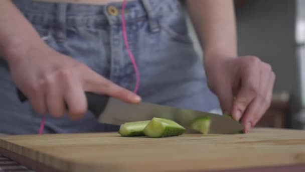 Vrouwelijke Handen Snijden Komkommer Met Mes Plakjes Keukenbord Closeup Meisje — Stockvideo