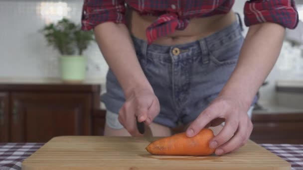 Vrouw Snijden Wortel Houten Bord Aan Keukentafel Video — Stockvideo