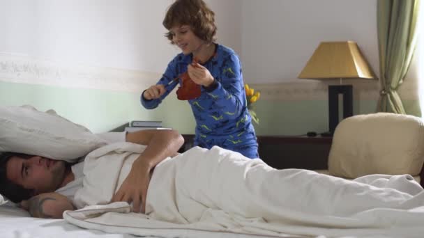 Der Ältere Bruder Schläft Bett Und Der Kleine Bruder Weckt — Stockvideo