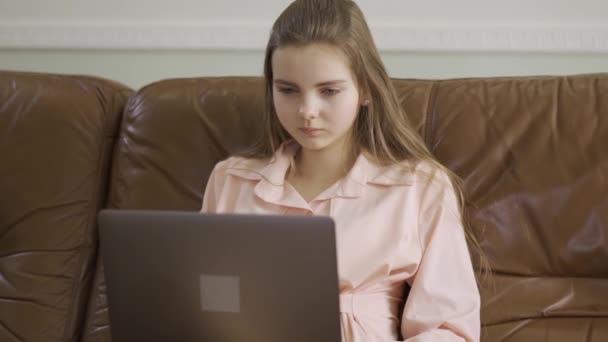 Menina Elegante Concentrado Sentado Sofá Couro Digitando Teclado Laptop Lazer — Vídeo de Stock