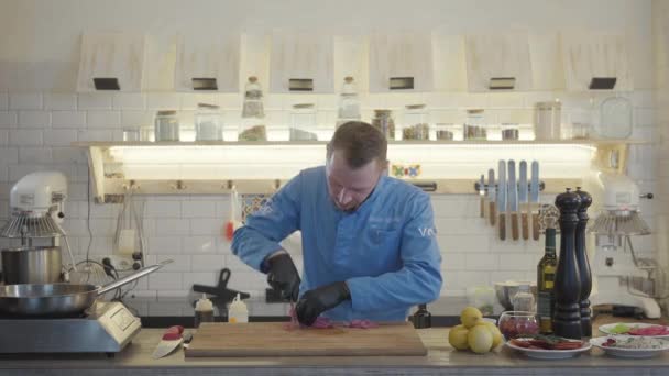 Ein Junger Mann Kochuniform Schneidet Mit Einem Großen Messer Grünzeug — Stockvideo