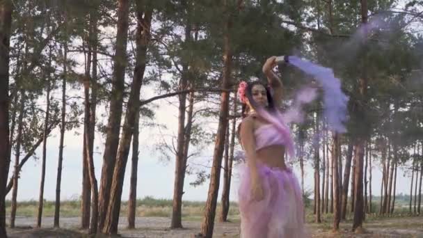 연분홍 드레스를 소나무 뒤에서 연막탄을 아름다운 — 비디오