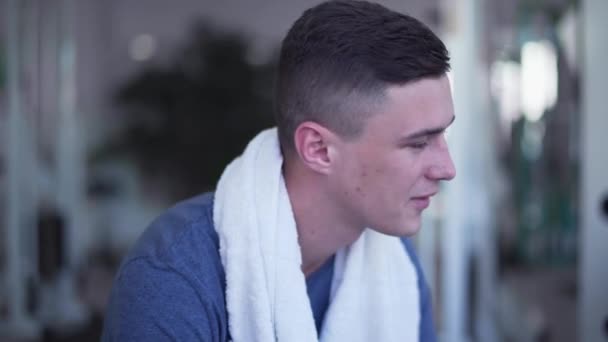 Samiec Pije Wodę Siłowni Młody Człowiek Białym Ręcznikiem Szyi Odpoczywa — Wideo stockowe