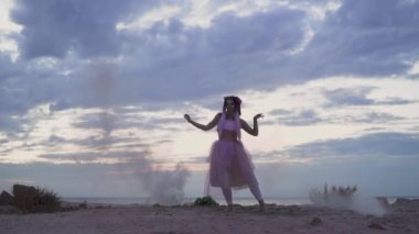 Pembe elbiseli, parlak makyajlı güzel bir kız. Dışarıdaki sis bombalarının dumanında dans ediyor..