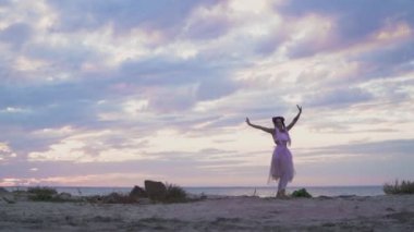 Açık havada dans eden pembe elbiseli, parlak makyajlı güzel kız..