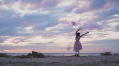 Açık havada dans eden pembe elbiseli, parlak makyajlı güzel kız..