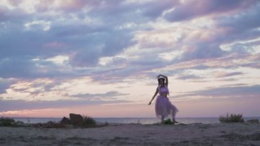 Açık havada dans eden pembe elbiseli, parlak makyajlı güzel kız..