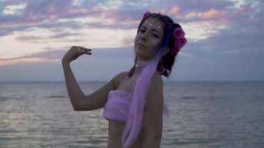 Açık havada dans eden pembe elbiseli, parlak makyajlı güzel kız..