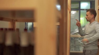 Şarap şişesindeki yazıtları inceleyen yakışıklı bir adam. Müşteri içki dükkanında içmeyi tercih ediyor. Erkek tatmin olur, şişeyi alır ve uzaklaşır.