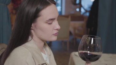 Güzel dolgun dudaklı, temiz tenli, restoranda kırmızı şarap içen güzel bir genç kız. Ağız manzarasını kapat