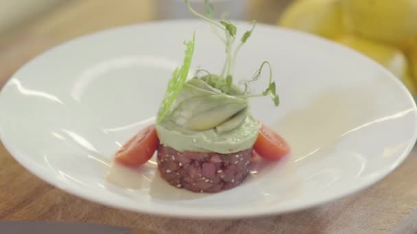 白色的大盘子 上面装饰着一道绝妙的菜 圆圆的小金枪鱼 顶部有美味的腊肉和青菜 漂亮的装饰盘 膳食设计 — 图库视频影像