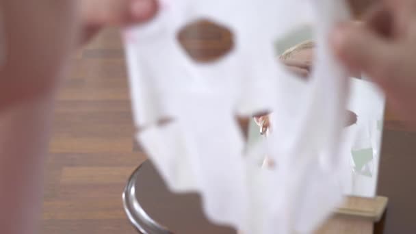 Hermosa Anciana Mirando Espejo Aplicando Mascarilla Hoja Para Cara Casa — Vídeos de Stock