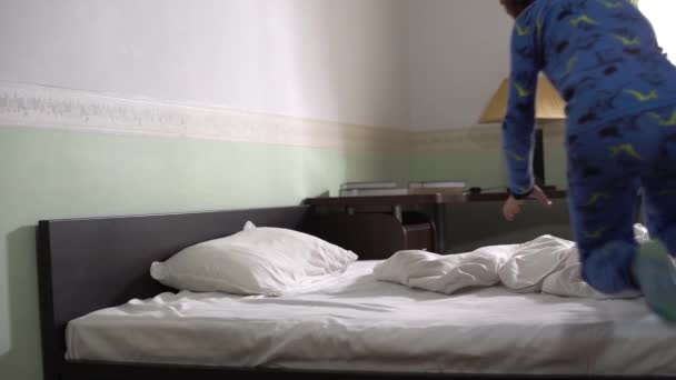 可爱的小男孩在卧室里跑来跑去 在床上跳得很快 假装睡着了 — 图库视频影像