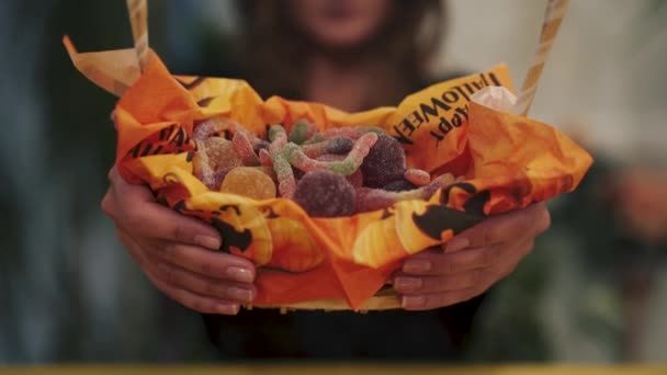 お菓子のバスケットのクローズアップ 女の子はカメラからバスケットを取ります ハロウィーンの休日 ビデオ — ストック動画