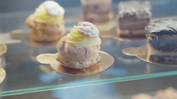 Zárja Eclaireket Csokoládés Süteményeket Üvegvitrinben Édességek Boltjában — Stock videók