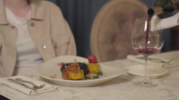 Cameriere Versando Vino Rosso Nel Bicchiere Visita Femminile Vicino Piatto — Video Stock