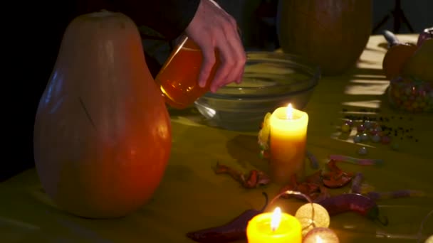 两个魔术师正在准备在圣夜的药水 雄手将魔法液体倒入碗中 女性的手把神奇的香料扔在碗里 万圣节假期录像 — 图库视频影像