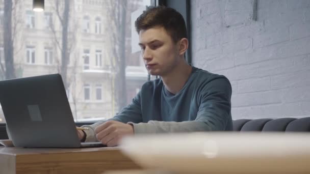 Cup Coffee Standing Table Foreground Close Young Man Working Laptop — Stock Video