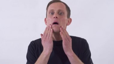 Komik genç adam garip suratlar yapıyor. Beyaz bir arkaplanda çekim.