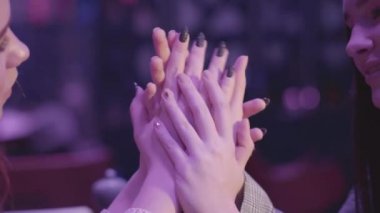 Mavi ışıkta el ele tutuşan iki güzel lezbiyen çiftin portresi. Kız arkadaşlar mutlu ve gülümsüyor. Lgbt aşk ve ilişki kavramı