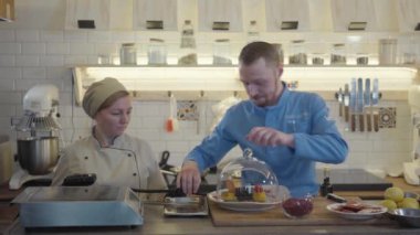 Profesyonel aşçı ve pasta şefi büyüleyici bir servis için çanağa duman ya da buhar ekliyor.