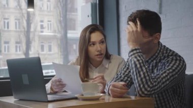 Genç bir adamla kızın rahat bir kafe ya da restoranın penceresinin yanında dizüstü bilgisayarlı bir şekilde oturduğu portre. Arkadaşlar planlara ve programlara bakar ve gelecek planları tartışırlar..